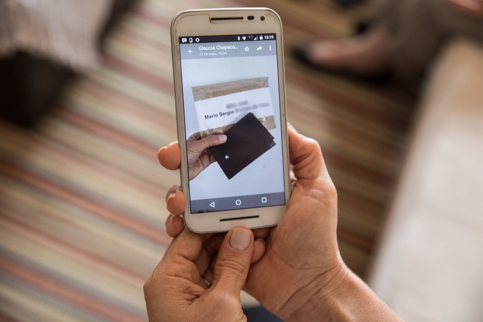 Embalagem fechada e nominal com carteira de v&iacute;tima foi aberta e exposta em grupo de mensagens (Foto: F&aacute;bio Tito/G1)