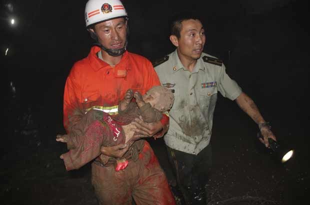 Bebê é resgatada de buraco de rua na China nesta terça-feira (14) (Foto: Xinhua/AP)