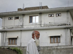 Morador passa nesta quinta-feira (5) em frente à casa em que, segundo os EUA, Osama bin Laden foi morto em Abbotabad (Foto: AP)