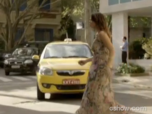 Juliana atravessa a rua e nem vê o táxi vindo (Foto: Em Família/TV Globo)