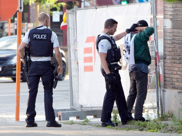 Policiais checam a identidade de um homem perto da sede do Departamento de Polícia em Charleroi, na Bélgica, no sábado (6) (Foto: AP Photo/Virginia Mayo) Policiais checam a identidade de um homem perto da sede do Departamento de Polícia em Charleroi, na Bélgica, no sábado (6) (Foto: AP Photo/Virginia Mayo)
