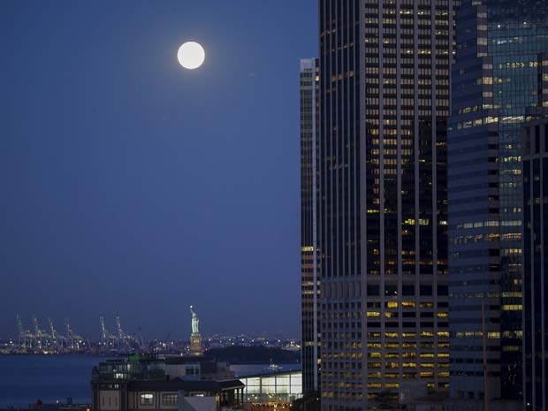 Lua azul, chamada assim por ser a segunda lua cheia do mês, é vista perto da Estátua de Liberdade, em Nova York, nesta sexta-feira (31) (Foto: REUTERS/Eduardo Munoz)