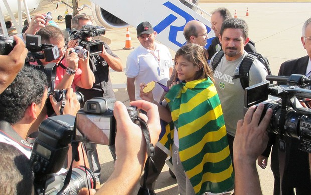Sarah e Expedito Falcão cercado por repórteres ainda na pista, Chegada Sarah Menezes (Foto: Raphael Andriolo / Globoesporte.com)