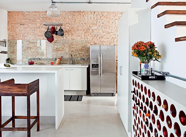No projeto da arquiteta Rachel Nakata, a cozinha é integrada à sala. A adega, feita com tijolos cilíndricos de cerâmica, fica encostada na escada (Foto: Lufe Gomes/Casa e Jardim)