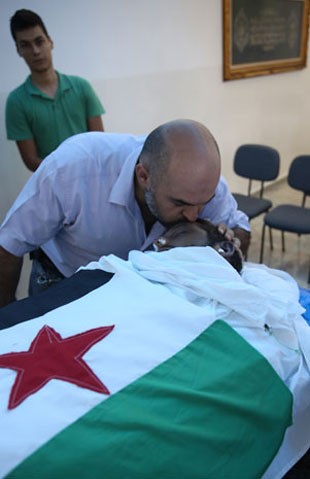 O sírio Amer Masarani beija o corpo do amigo (Foto: Gabriel Chaim/G1)