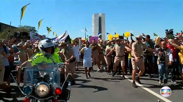 Manifestantescontra e a favor do impeachment se aproximam de condutores da tocha olímpica em Brasília (Foto: TV Globo/Reprodução) Manifestantescontra e a favor do impeachment se aproximam de condutores da tocha olímpica em Brasília (Foto: TV Globo/Reprodução)
