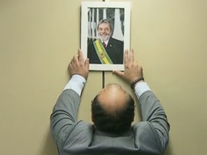Líder do PR na Câmara, deputado Bernardo Santana, pendura na parede retrato oficial do ex-presidente Lula (Foto: Reprodução / GloboNews)