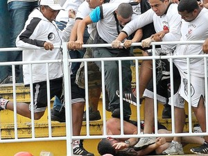 Vândalos com a camisa do Vasco pisoteiam homem encurralado na arquibancada da Arena Joinville (Foto: Reuters) Vândalos com a camisa do Vasco pisoteiam homem encurralado na arquibancada da Arena Joinville (Foto: Reuters)