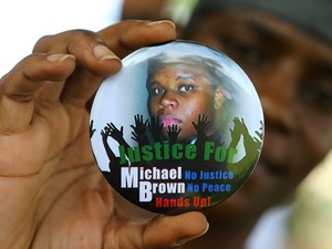 Manifestante segura botton de apoio a Michael Brown, morto por policial em Ferguson (EUA) (Foto: Atlanta Journal Constitution/AP)
