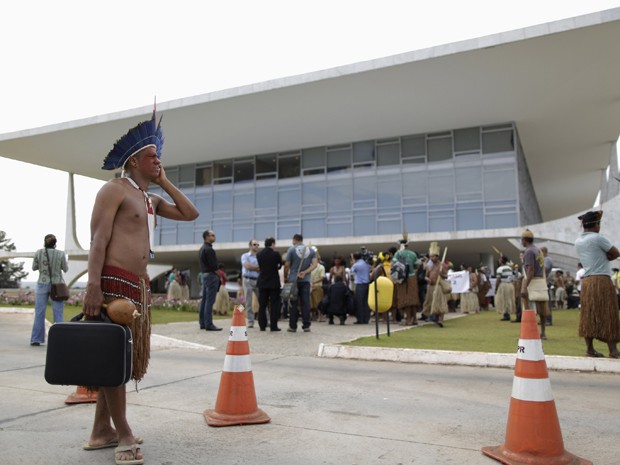 Indígena que participa de protesto em Brasília contra projetos de demarcação de terra fala ao celular (Foto: Ueslei Marcelino/Reuters)