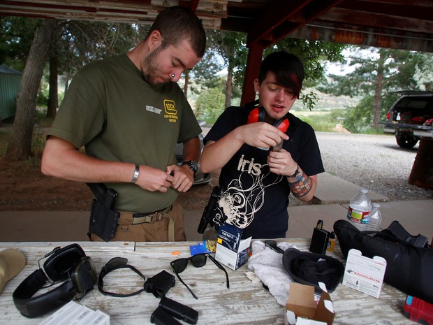 Presidente do Pink Pistols, Matt Schlentz, e Skylar Simon colocam munição nas armas (Foto: REUTERS/Jim Urquhart)
