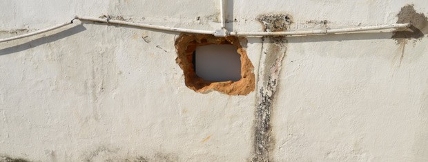 Homens tiveram acesso a agência bancária perfurando um buraco na parede (Foto: Walter Paparazzo/G1)