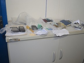 Drogas, facas e celulares apreendidos (Foto: Rogério Aderbal/G1)