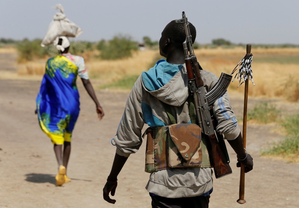 Homem armado anda perto da vila sul-sudanesa de Nialdhiu (Foto: Siegfried Modola/Reuters)