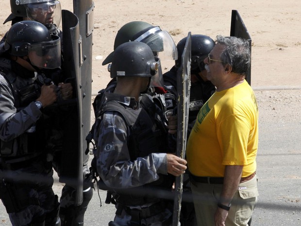 Homem fica parado enquanto policiais se aproximam para conter manifestantes (Foto: Paulo Whitaker/Reuters)