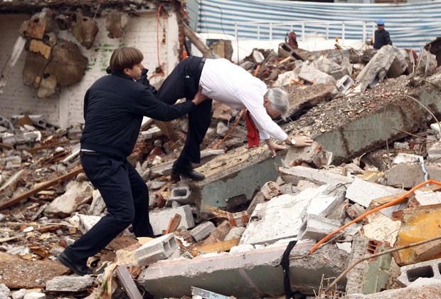 O presidente do Chile, Sebastian Piñera, tropeça e cai durante visita a escombros perto de Santiago (Foto: Sebastián Rodríguez/AFP)