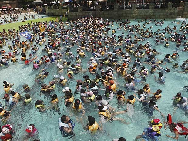 A onda de calor que atingiu a Coreia do Sul anda levando milhares de sul-coreanos à procura dos parques aquáticos. Neste domingo (5), foi preciso disputar espaço nas piscinas do Caribe Bay, em Yongin. (Foto: Ahn Young-joon / AP Photo)