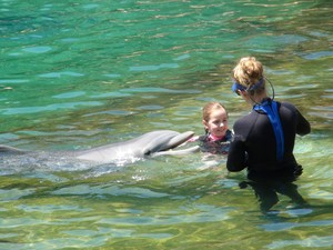 Treinadora com visitante na interaçõa com golfinhos do Discovery Cove, em Orlando (Foto: Flávia Mantovani/G1)