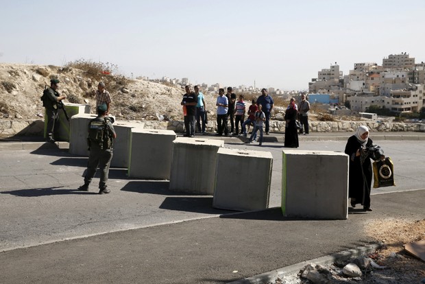 Palestino passa por verificação da identidade em bloqueio montado por forças de segurança israelenses. Polícia tenta conter onda de ataques com faca feitos por palestinos (Foto: Baz Ratner/ Reuters)