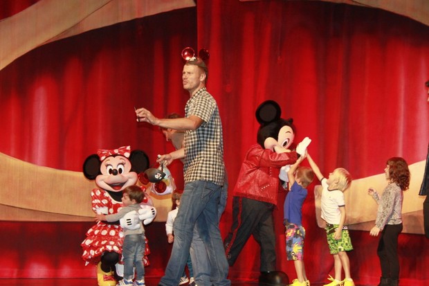 Rodrigo Hilbert tentou registrar o momento com o celular enquanto so filhos cumprimentaval Mickey no palco (Foto: Isac Luz/EGO)