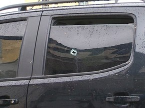 Veículo dirigido pelo adolescente está na Delegacia de Escada para ser periciado. Marca do tiro pode ser visto no vidro da janela traseira (Foto: Reprodução / TV Globo)
