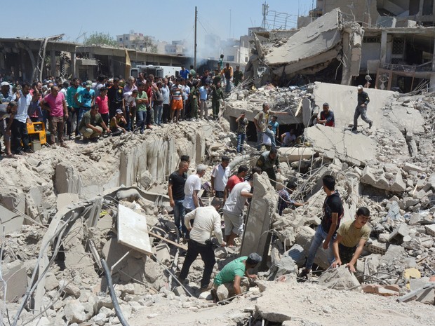 Populares buscam sobreviventes sob escombros após duas explosões na cidade síria de Qamishli, na manhã desta quarta-feira (27) (Foto: Rodi Said/ Reuters)