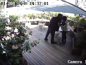 Câmera de segurança do restaurante mostra o policial civil dando um beijo na mulher no encontro antes de ela ir à loja do comerciante (Foto: Reprodução/TV Globo)
