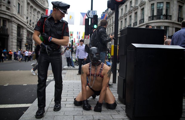 Policial observa participante da parada gay em Londres, neste sábado (7) (Foto: Andrew Cowie / AFP)
