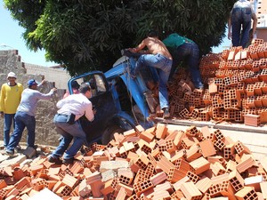 Populares tentam resgatar motorista das ferragens do caminhão  (Foto: Gil Oliveira/ G1)