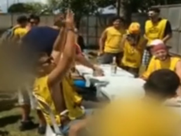 De braços pra cima, estudante comemora após tomar outra dose de vodca (Foto: Reprodução/TV Globo)
