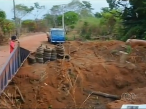 Moradores fizeram obstáculos para evitar que a terra caia no córrego (Foto: Reprodução/TV Anhanguera)