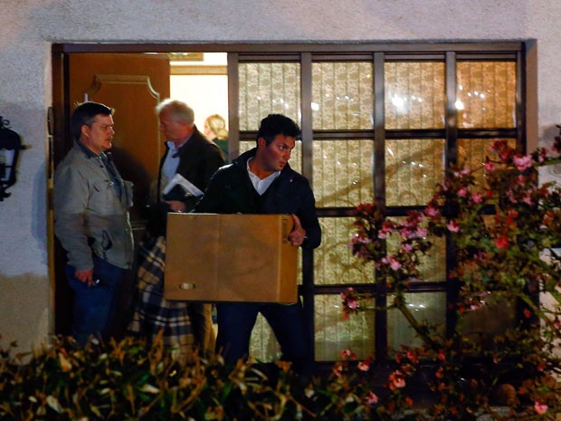 Policial deixa casa do copiloto Andreas Lubitz em Montabaur, na Alemanha, carregando objetos pessoais dele (Foto: Kai Pfaffenbach/Reuters)