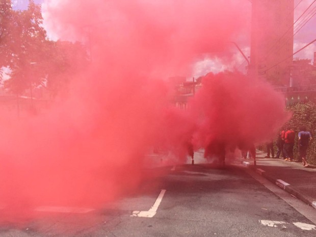 Fumaça vermelha é lançada por manifestantes em frente a prédio onde mora o ex-presidente (Foto: Carolina Dantas / G1)