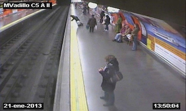 Mulher desmaia e cai sobre trilhos no metrô de Madri (Foto: BBC)