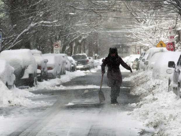 Mulher ajuda a retirar neve de uma rua em Jersey City, Nova Jersey. (Foto: Eduardo Munoz / Reuters)
