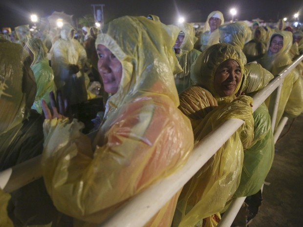 Peregrinos enfrentam a chuva e fortes ventos na chegada do Papa Francisco no aeroporto de Tacloban (Foto: Damir Sagolj/Reuters)