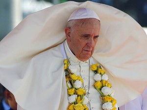 O vento ergue parte da veste do Papa Francisco, que foi recebido com um colar de flores na chegada ao aeroporto de Colombo, no Sri Lanka, onde cumpre a primeira visita papal em 20 anos (Foto: Stefano Rellandrini/Reuters)