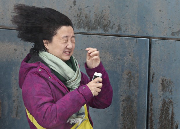 Mulher faz careta ao batalhar contra o vento durante tempestade de neve no Canadá (Foto: Mathieu Belanger/Reuters)