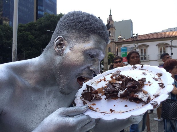 Homem prateado come restos de bolo para celebrar prisão de Sérgio Cabral (Foto: Gabriel Barreira/ G1)