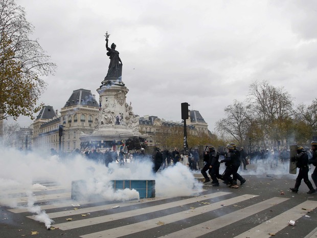  Nuvens de gás lacrimogêneo são vistas durante protesto entre manifestantes e policiais na Para da República em Paris neste domingo (29) (Foto: Eric Gaillard/Reuters)