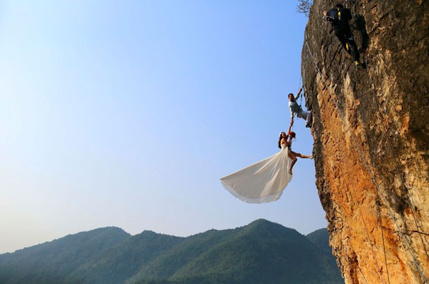 Alpinista amador, o chinês Zheng Feng posou para fotos de casamento com sua noiva em penhasco (Foto: China Daily/Reuters) Alpinista amador, o chinês Zheng Feng posou para fotos de casamento com sua noiva em penhasco (Foto: China Daily/Reuters)
