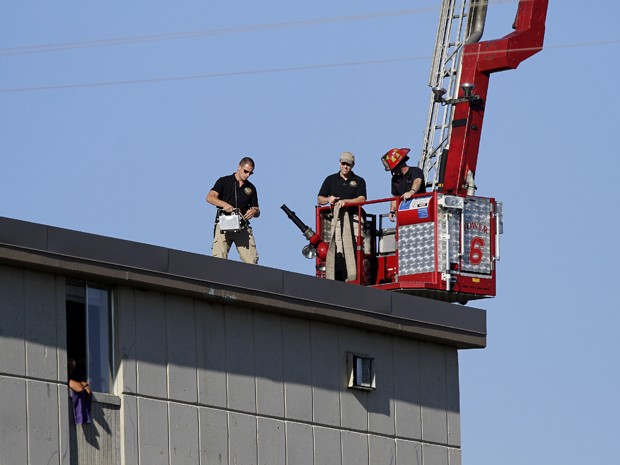 Oficiais colocam dispositivo controlado remotamente no topo do prédio onde estão os explosivos (Foto: Joshua Lott/ REUTERS)