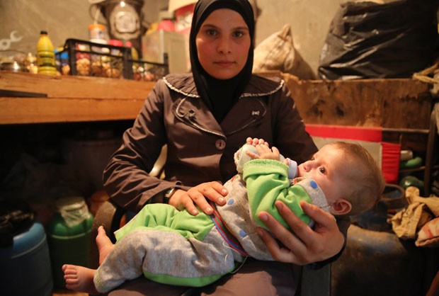 A síria Mariam com a menina Mais, de seis meses; após sobreviver a um bombardeio que matou todos os moradores de um prédio, o bebê de seis meses ganhou um novo lar (Foto: Gabriel Chaim)