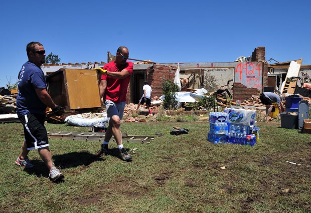 Na foto, Josh Stapleton (esq) e Dan Garrett ajudam a resgatar móveis da casa de seus amigos Fred e Joann Horn (Foto: Nick Oxford/AP Photo)
