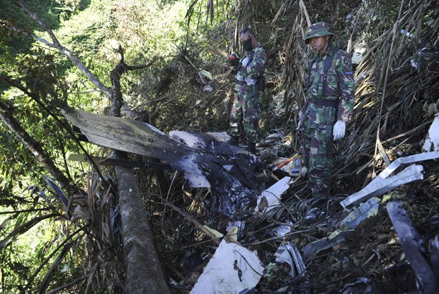 Soldados trabalham entre os destroços do avião russo neste sábado (12) (Foto: AP)