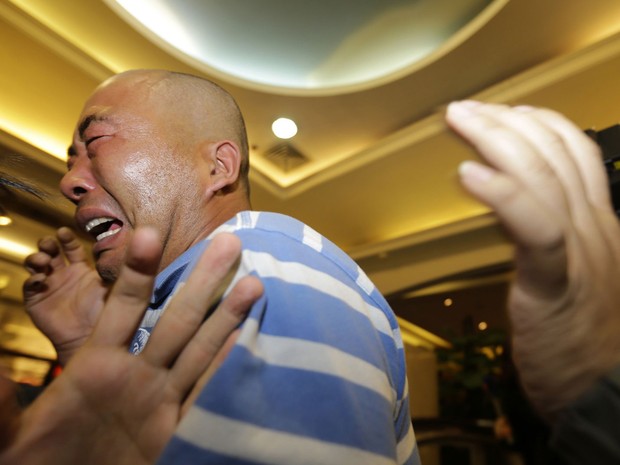 Parente de um passageiro do avio da Malaysian Airlines se desespera aps ouvir anncio que a aeronave caiu no mar (Foto: Jason Lee/Reuters)