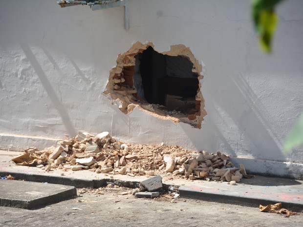Buraco feito pelos bandidos na parede do banco (Foto: Walter Paparazzo/G1)