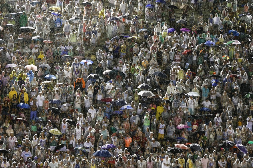 Debaixo de forte chuva, quem foi à Sapucaí para o primeiro dia de desfiles teve de se proteger da forma que pode