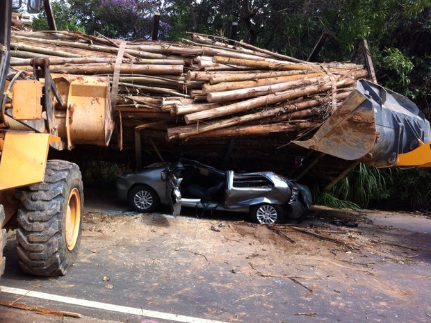 Caminhão carregado com tora de madeira tombou em cima de carro (Foto: Moisés Soares / TV TEM)