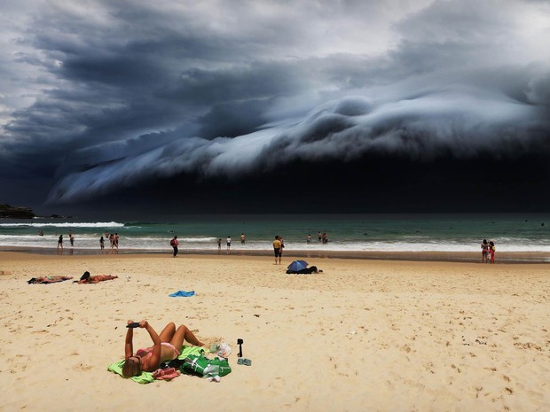 Formação de uma 'nuvem tsunami' na praia de Bondi, em Sydney, enquanto uma banhista lê um e-book foi a vencedora na categoria 'Natureza' (Foto: Rohan Kelly/World Press Photo 2016)